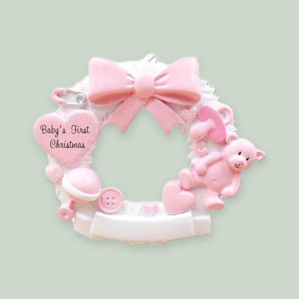 Baby Christmas Wreath (Pink) ornament on a sage green background