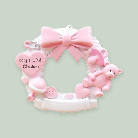 Baby Christmas Wreath (Pink) ornament on a sage green background