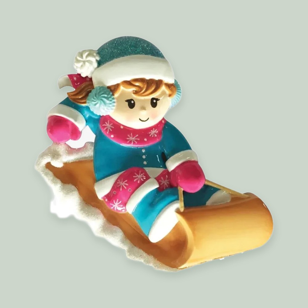 Girl on a Sled ornament on a sage green background
