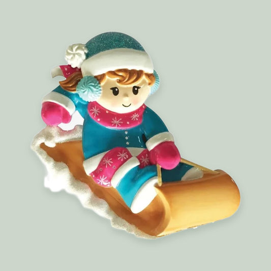 Girl on a Sled ornament on a sage green background