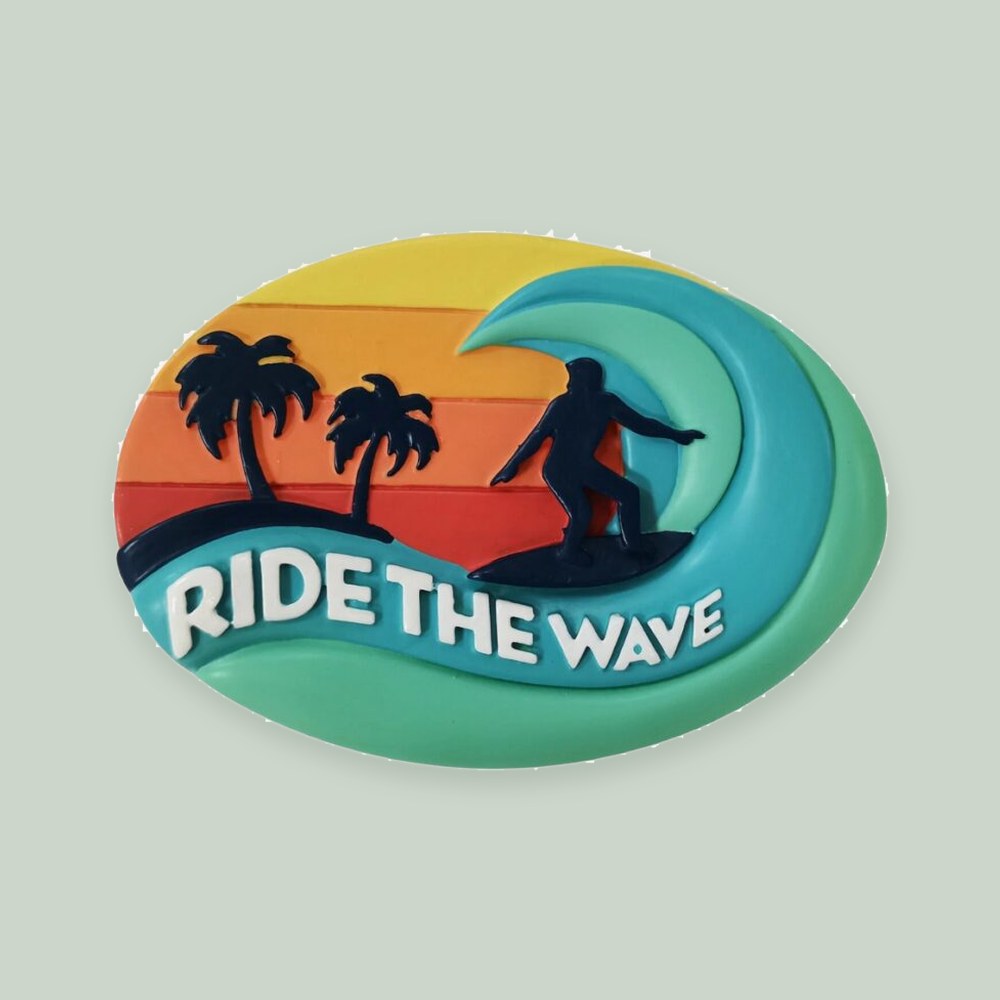 Surfboard “Ride the Wave” ornament on a sage green background