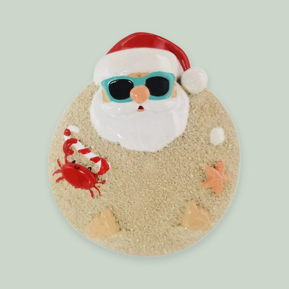 Sand Santa ornament on a sage green background