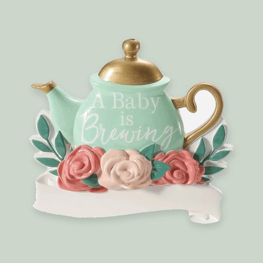 A Baby Is Brewing ornament on a sage green background