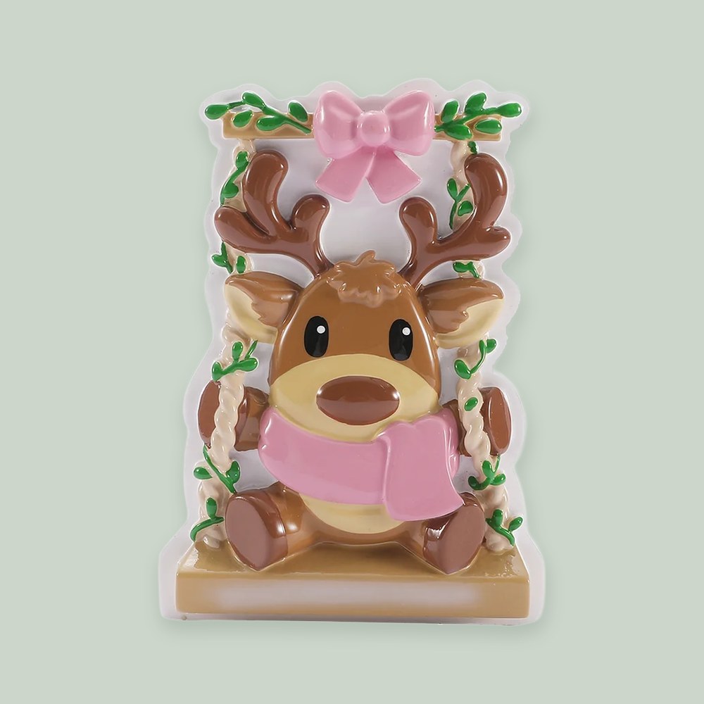 Baby Reindeer on a Garden Swing- Pink ornament on a sage green background