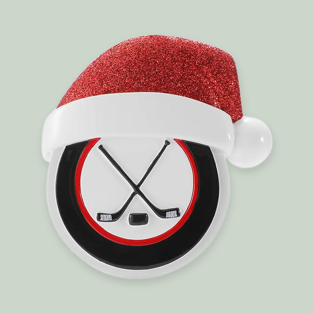 Hockey Puck with Santa Hat ornament on a sage green background