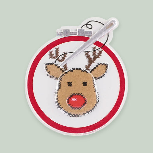 Cross Stitching Reindeer ornament on a sage green background