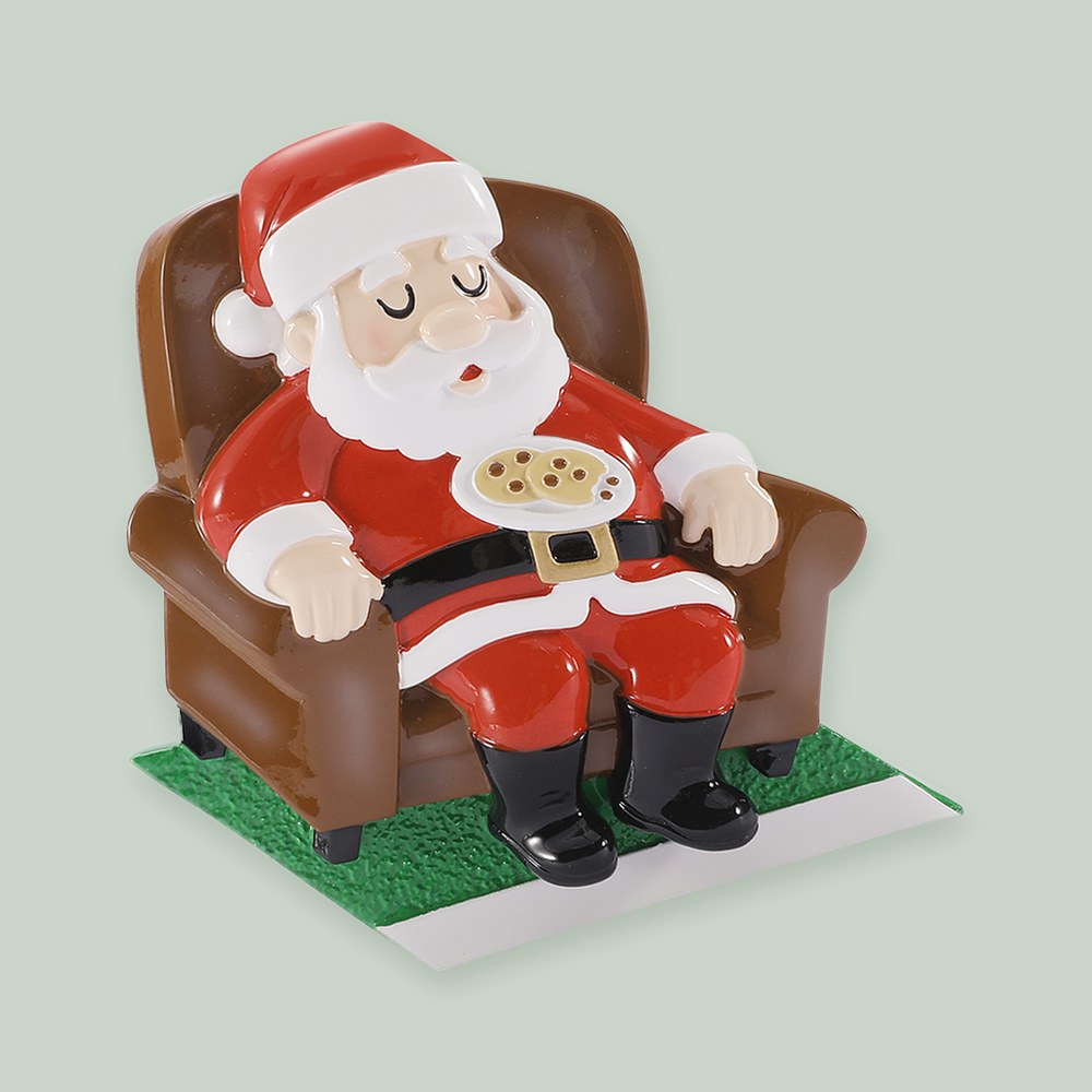 Sleepy Santa On A Chair With Cookies ornament on a sage green background